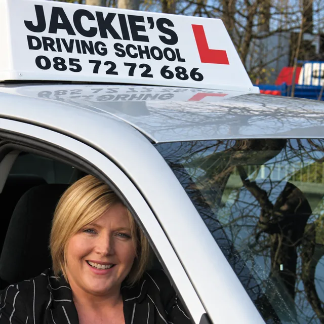 Jacqueline Moran smiling from the driver’s seat of the school car