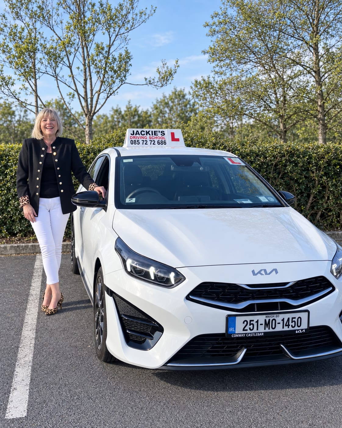 Jacqueline Moran smiling beside her white Kia school car